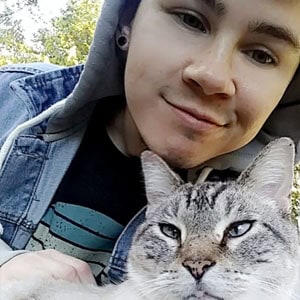 Happy young woman with her cat outdoors, showcasing caring pet sitting services.