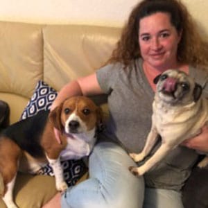 Dog and woman relaxing on a beige couch at Lakeside Pet Sitting.