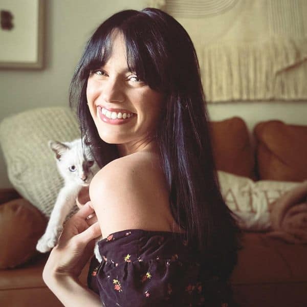 Woman holding a cat in a cozy living room, pet sitting at home.